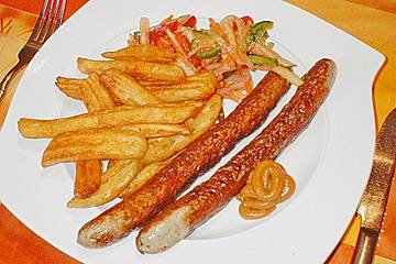 Schlangenwurst mit frittierten Riffelkartoffeln an buntem Streifensalat