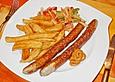 Schlangenwurst mit frittierten Riffelkartoffeln an buntem Streifensalat