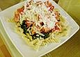Gesundes Nudelgericht mit Blattspinat und Tomaten
