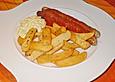 Ger&ouml;stete Bratwurst mit Curry - Tomaten - Ahorn - Sauce an gekr&auml;uterten Frites