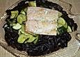 Lachsfilet in einem Bett aus schwarzen Bandnudeln mit Zucchinigem&uuml;se