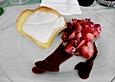 Wei&szlig;e Schokoladenmousse in Orangenhippen an frischen Erdbeeren