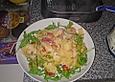 Bandnudeln Aglio e Olio mit Cocktailtomaten und Shrimps auf einem Bett aus Rucola