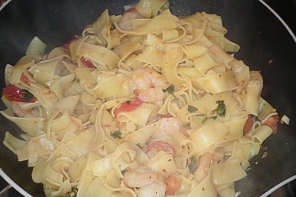 Bandnudeln Aglio e Olio mit Cocktailtomaten und Shrimps auf einem Bett aus Rucola 2