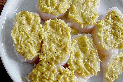 Blaulengmedaillons unter der Kartoffelkruste in einem Nest aus Zucchinistreifen