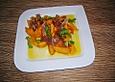 Fruchtsalat in orange mit Parmaschinken