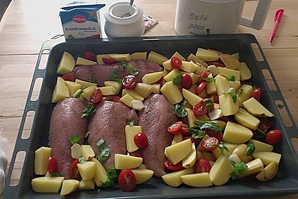 Knoblauch-H&uuml;hnchen mit Kartoffeln und Tomaten auf dem Backblech