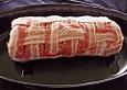 Rollbraten aus grobem Bratwurstteig, gerollt in ein Bacongitter