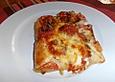 Pizza mit Tomaten, Basilikum, Mozzarella und Parmesan