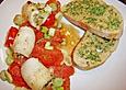 Gef&uuml;llte Schollenr&ouml;llchen auf Tomaten mit ger&ouml;stetem Baguette