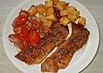 Schweineschnitzel mit Tomatensalat an groben Kartoffelw&uuml;rfeln