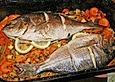 Ganzer Fisch auf Kartoffeln und Gem&uuml;se