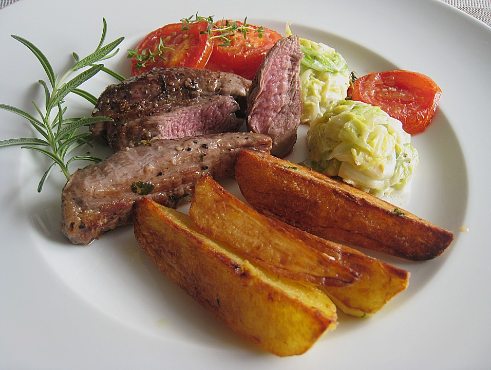 Lammfilet an Wirsing, geschmorten Tomatenscheiben und gebratenen ...