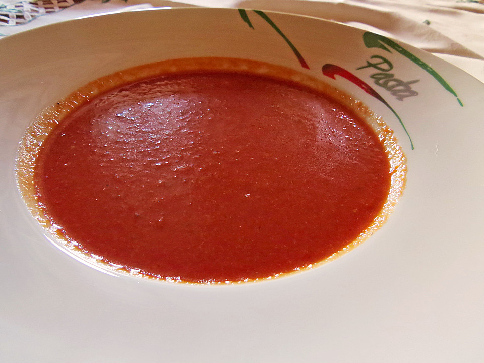 Ein Glas Gazpacho-Suppe mit frischen Tomaten, Gurken, Zwiebeln und Knoblauch.