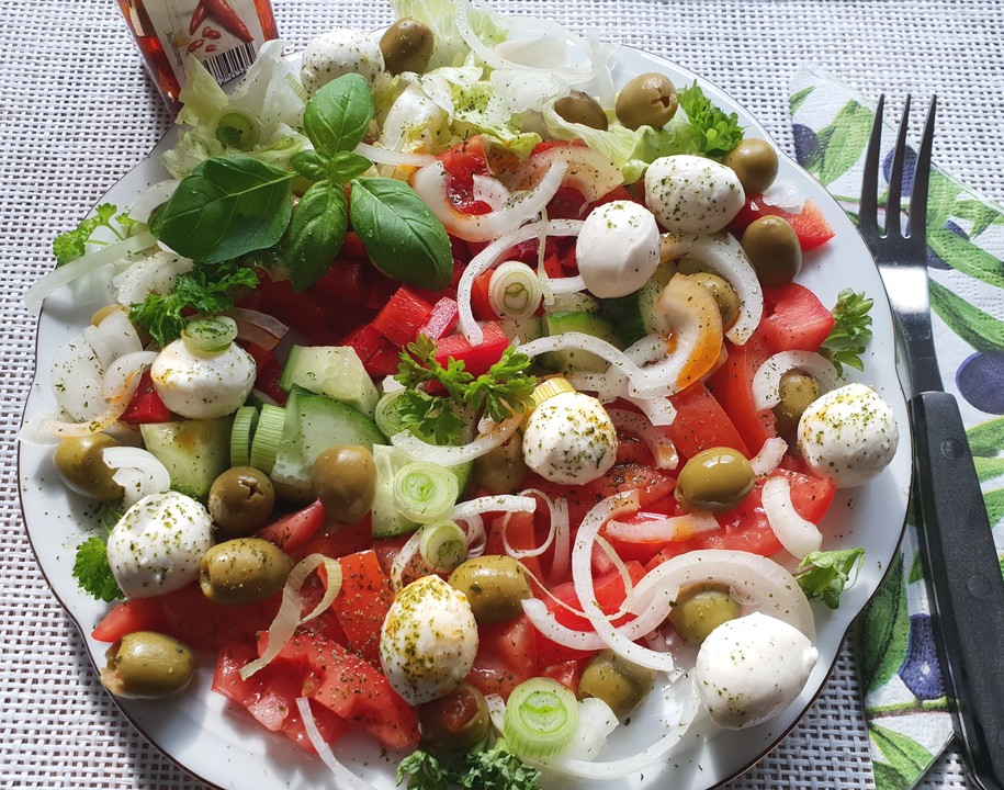 Salat mit Oliven, Mini-Mozzarella, Paprika, Tomaten, Zwiebeln und ...