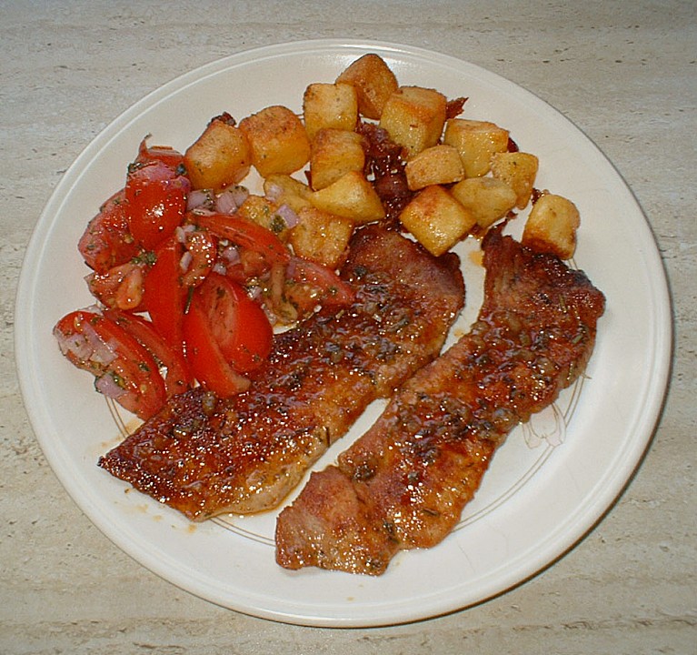 Schweineschnitzel mit Tomatensalat an groben Kartoffelwürfeln von ...
